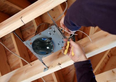 electrical contractor installing lights in ceiling